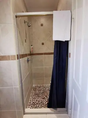 a bathroom with a shower with a glass door at Sleep Eezy Cottages in Benoni