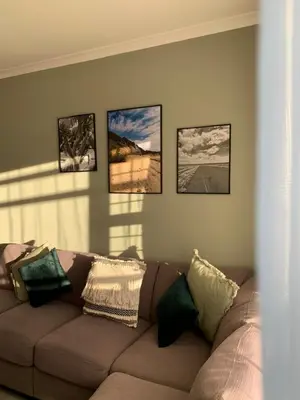 a couch in a living room with four pictures on the wall at Waterfall Views in Midrand
