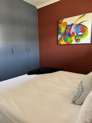 a bedroom with a bed with a painting on the wall at Waterfall Views in Midrand