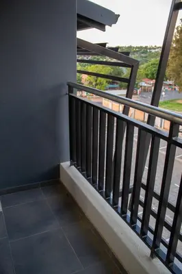 a balcony with a black railing and a view at Waterfall Views in Midrand