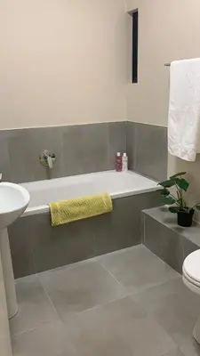 a bathroom with a bath tub and a sink at Waterfall Views in Midrand