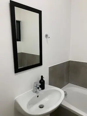 a bathroom with a white sink and a mirror at Waterfall Views in Midrand