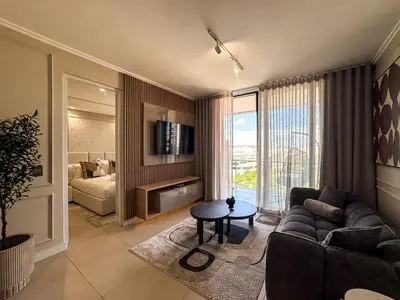 a living room with a couch and a bed at Luxe 4608 Ellipse Waterfall in Midrand