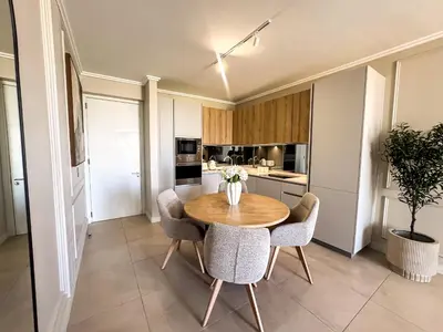 a kitchen with a wooden table and chairs at Luxe 4608 Ellipse Waterfall in Midrand