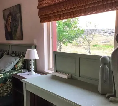 a living room with a window and a table with a lamp at Corner View Accommodation in Kaapsehoop