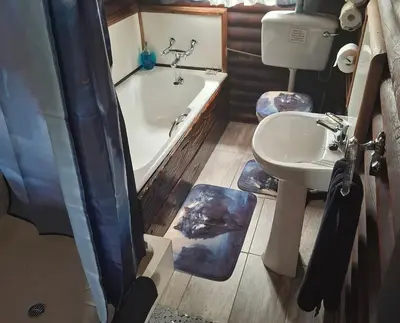 a bathroom with a tub and a sink and a toilet at AmaZeng chalet Wolf in Lydenburg