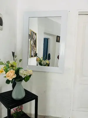 a vase with flowers on a table in front of a mirror at Hlatsi Bushview Apartments & Safaris in Hazyview