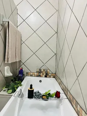 a bathroom with a bath tub with flowers in it at Hlatsi Bushview Apartments & Safaris in Hazyview