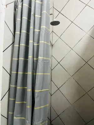 a shower with blue and yellow shower curtain at Hlatsi Bushview Apartments & Safaris in Hazyview