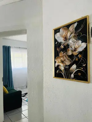 a painting of flowers on a wall in a living room at Hlatsi Bushview Apartments & Safaris in Hazyview