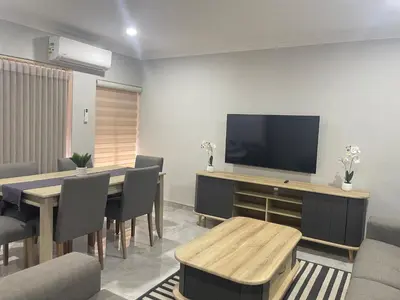a dining room with a table and a flat screen tv at Omega 8 in Polokwane