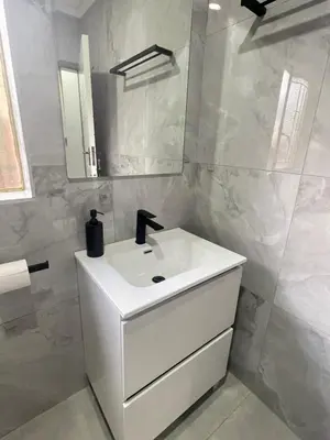 a white bathroom with a sink and a mirror at Omega 8 in Polokwane