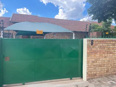 a green gate in front of a brick fence at Omega 8 in Polokwane