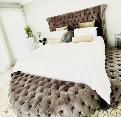 a bedroom with a large bed with white sheets and pillows at ALIMU villa Mbombela in Nelspruit