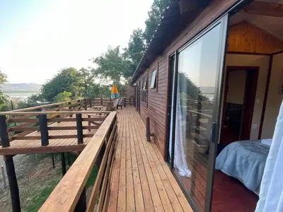 a wooden deck with benches on the side of a building at Heart Of The Cosmos in Hartbeespoort
