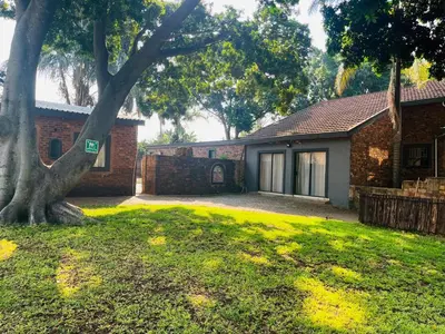 a house with a tree in the yard at Bluesky guest lodge in Pretoria