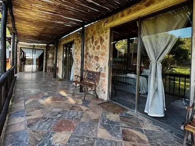 a porch of a stone house with a window at Sundara Safaris