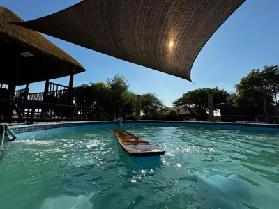 a swimming pool with a table in the water at Sundara Safaris