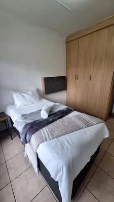 two beds sitting next to each other in a bedroom at Secure house in complex near OR Thambo airport in Johannesburg