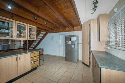 a kitchen with wooden cabinets and a refrigerator at Secure house in complex near OR Thambo airport in Johannesburg