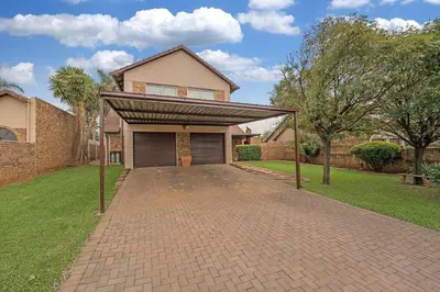 a brick driveway leading to a house with a garage at Secure house in complex near OR Thambo airport in Johannesburg