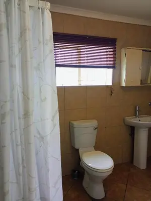 a bathroom with a toilet and a sink at The Tranquility Suite & Spa in Kempton Park