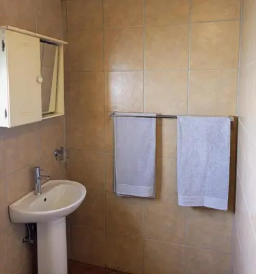 a bathroom with a sink and two white towels at The Tranquility Suite & Spa in Kempton Park