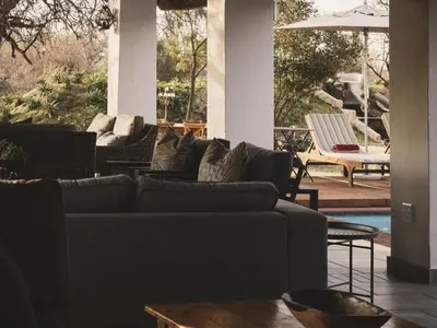 a living room with couches and a table and a pool at Tshikwalo Guest House in Hammanskraal