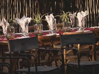 a long wooden table with chairs and glasses on it at Tshikwalo Guest House in Hammanskraal