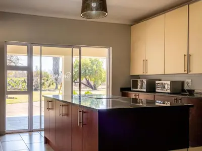 a kitchen with a large island in the middle at Tshikwalo Guest House in Hammanskraal