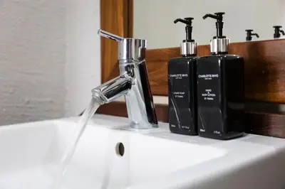 a bathroom sink with a faucet and two soap bottles at Landrift Villa in Phalaborwa