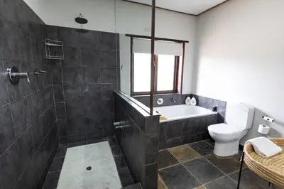 a bathroom with a tub and a toilet and a sink at Landrift Villa in Phalaborwa
