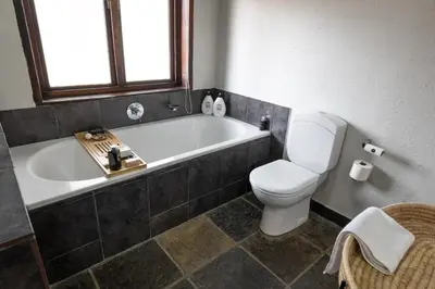 a bathroom with a tub and a toilet and a sink at Landrift Villa in Phalaborwa