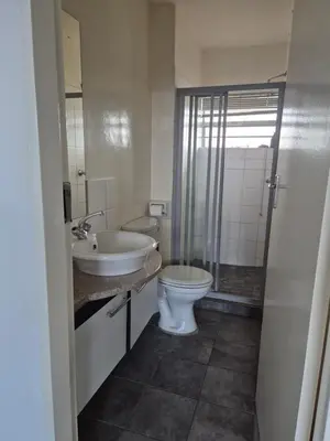 a bathroom with a toilet and a sink and a shower at Elegant studio apartment in Hillcrest in Pretoria