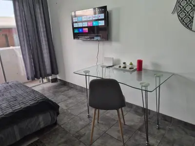 a room with a glass table and a chair at Elegant studio apartment in Hillcrest in Pretoria