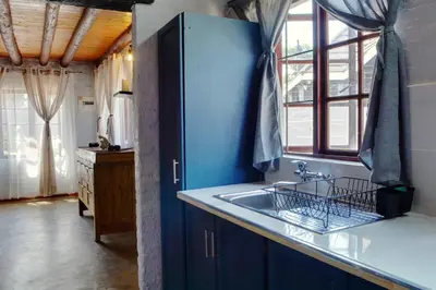 a kitchen with blue cabinets and a sink at Emathulini Holiday Home in Hazyview