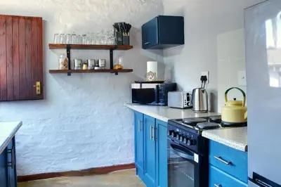 a kitchen with blue cabinets and a stove at Emathulini Holiday Home in Hazyview