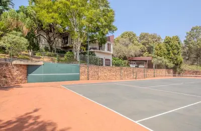 a tennis court in front of a house at Guesthouse Charis in Pretoria
