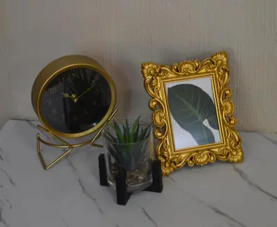 a mirror and a clock and a vase with a plant at Guesthouse Charis in Pretoria