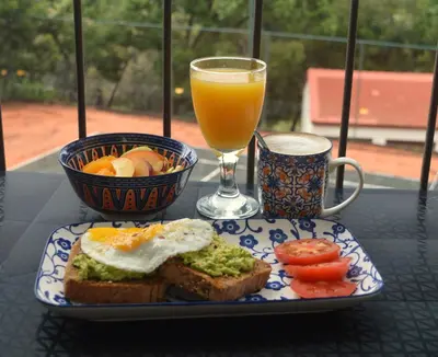 a plate of food with an egg and a glass of orange juice at Guesthouse Charis in Pretoria