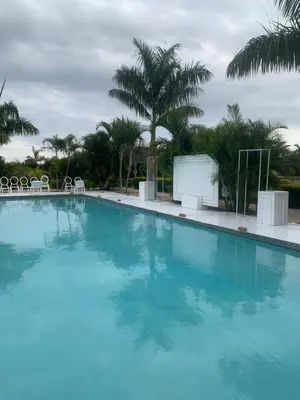 a large blue swimming pool with chairs and a screen at Florencepalms resort & Spa in Marble Hall