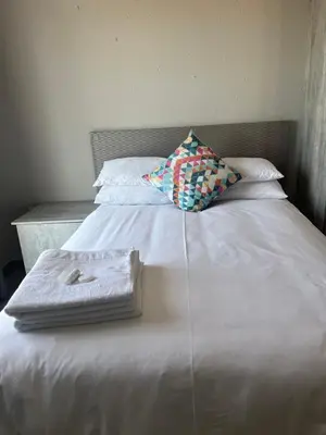 a white bed with a pillow and a tray on it at Florencepalms resort & Spa in Marble Hall