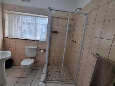 a bathroom with a shower and a toilet at Airport Inn Bed and Breakfast in Kempton Park