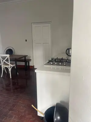 a kitchen with a stove and a table with chairs at Lani Accommodation in Pretoria