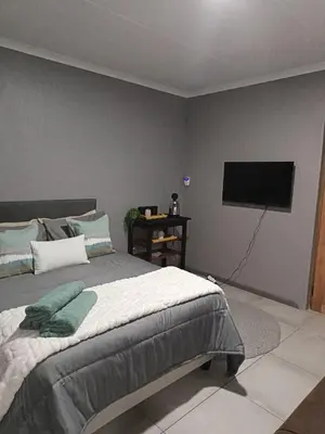 a bedroom with a bed and a flat screen tv at J & M Elegant escape 2 in Centurion