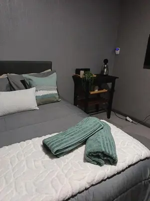 a bed with a green blanket on top of it at J & M Elegant escape 2 in Centurion