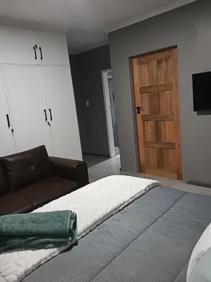a bedroom with a bed and a wooden door at J & M Elegant escape 2 in Centurion