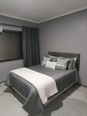 a bedroom with a large bed with pillows on it at J & M Elegant escape 2 in Centurion