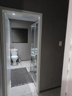 a bathroom with a toilet and a glass doorway at J & M Elegant escape 2 in Centurion