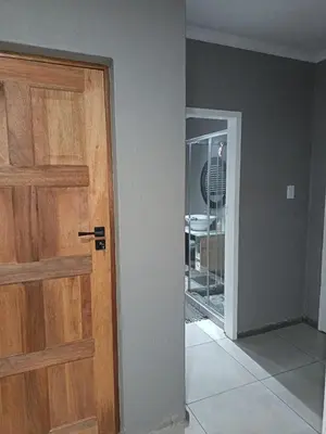 an empty room with a wooden door and a mirror at J & M Elegant escape 2 in Centurion